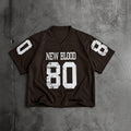A dark brown football-style jersey laid flat on a textured gray concrete background. The jersey has distressed white graphics, including the text 'NEW BLOOD' and the number '80' on the front, with the number '8' on each sleeve.
