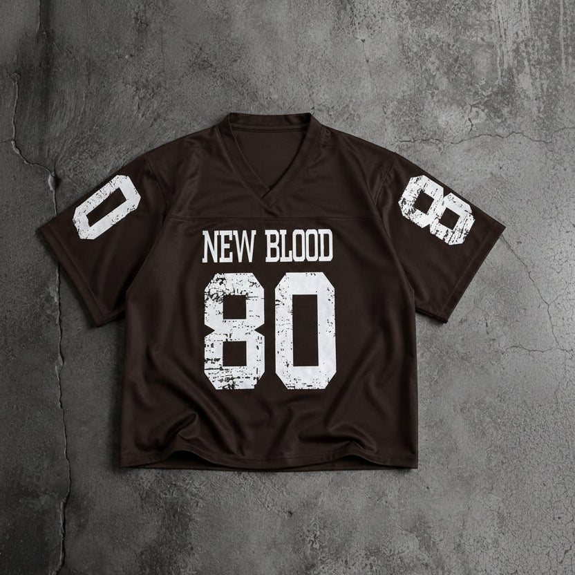 A dark brown football-style jersey laid flat on a textured gray concrete background. The jersey has distressed white graphics, including the text 'NEW BLOOD' and the number '80' on the front, with the number '8' on each sleeve.